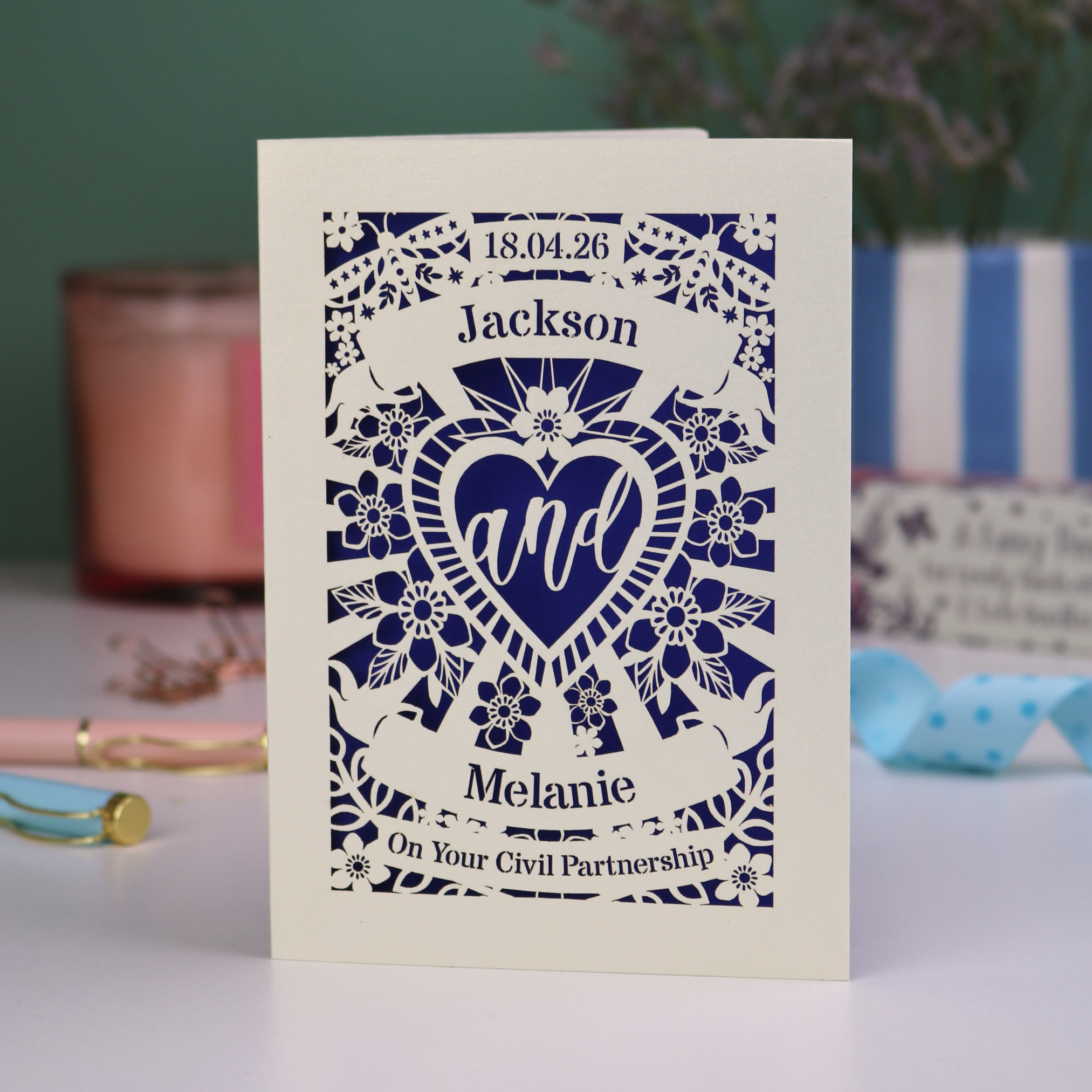 Personalized card with laser cut design and text on a table with decorative items.