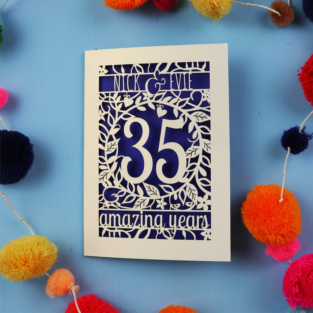 Personalised Coral anniversary Card with '35 amazing years' on a blue background with colourful pom-poms