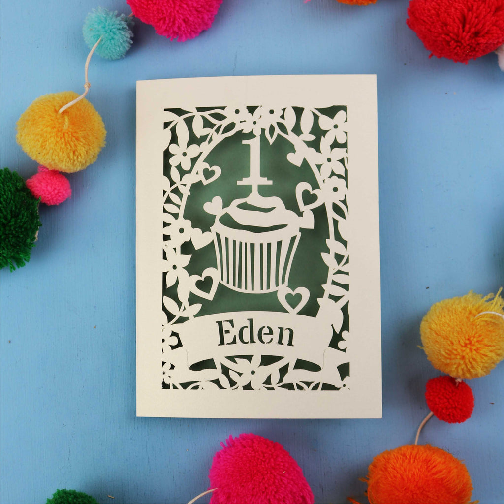 Special 1st birthday card with 'Eden' on a blue background with colourful pom-poms