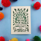 Birthday card with decorative design on a blue background with colourful pom-poms