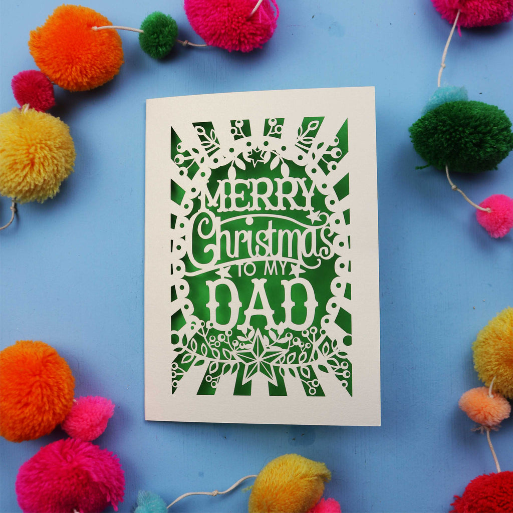 Dad Christmas card with 'Merry Christmas to my Dad' text on a blue background with colourful pom-poms.