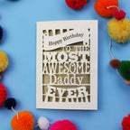 Birthday card for the most awesome daddy ever on a blue background with colourful pom-poms.