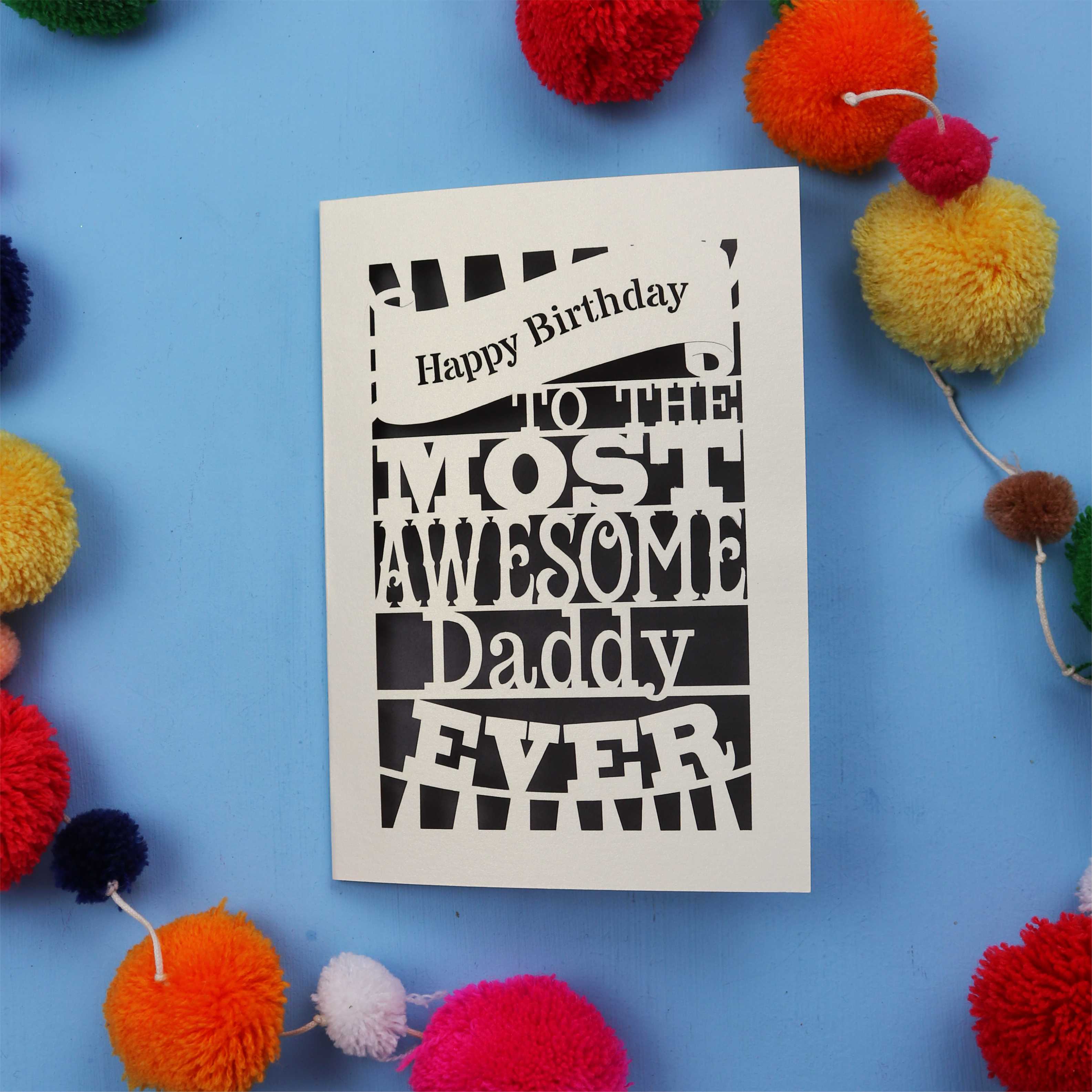 Daddy Birthday card with colourful text on a blue background with pom-poms