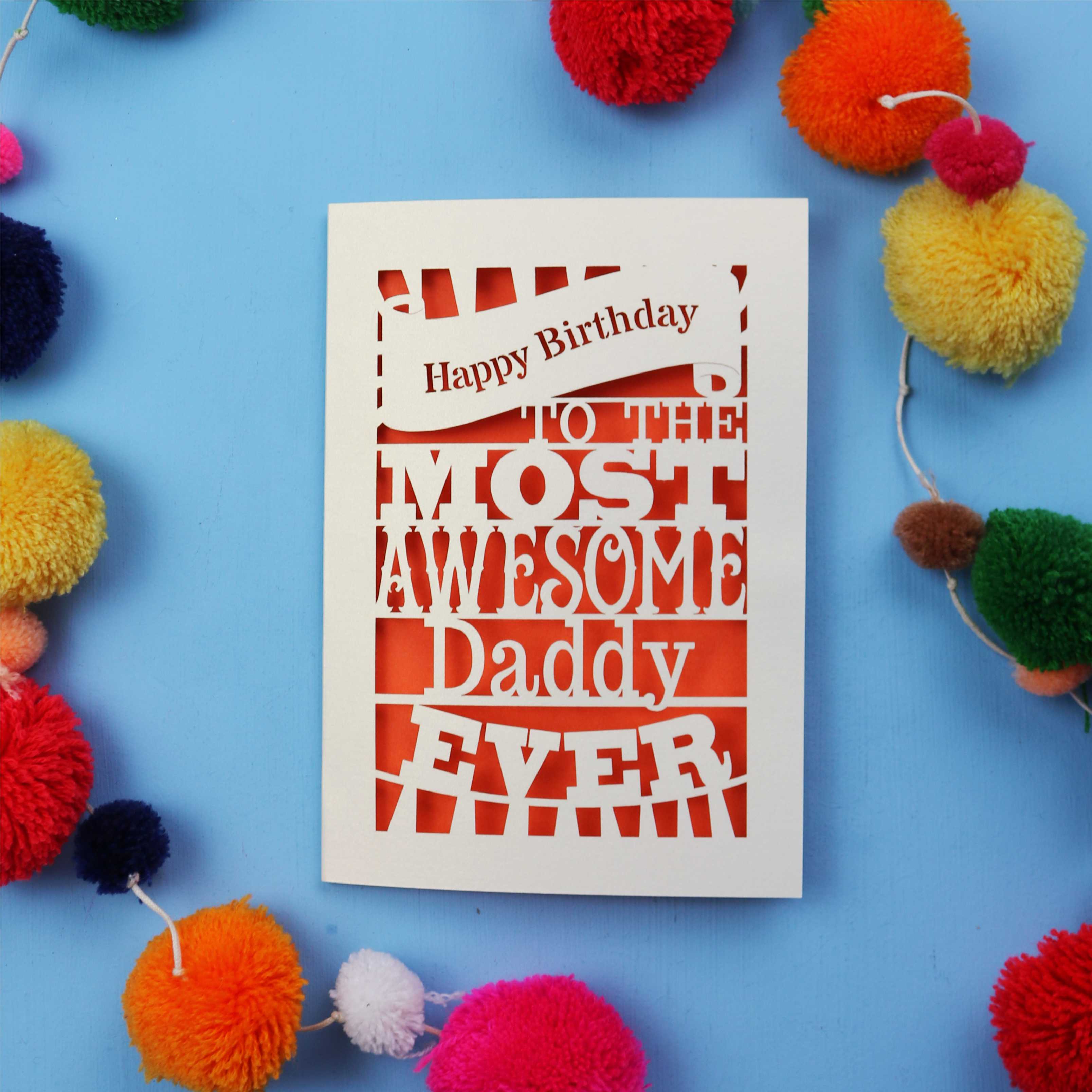Daddy Birthday card with colourful text on a blue background with pom-poms