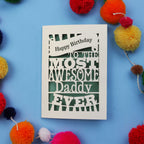 Daddy Birthday card with colourful text on a blue background with pom-poms