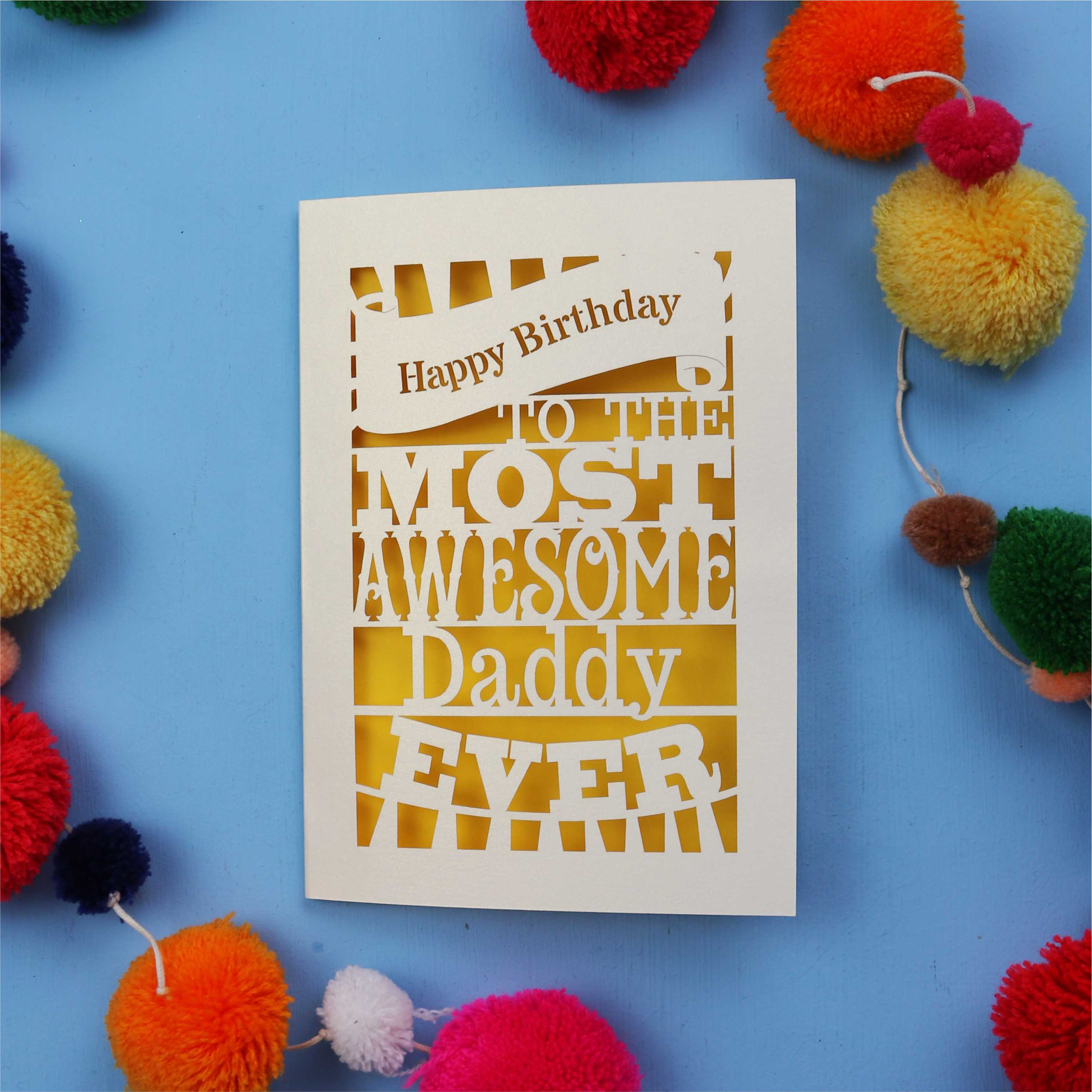 Daddy Birthday card with colourful text on a blue background with pom-poms