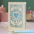 A cream laser cut sympathy card with cut out heart and flowers design and the text 'With Deepest Sympathy'