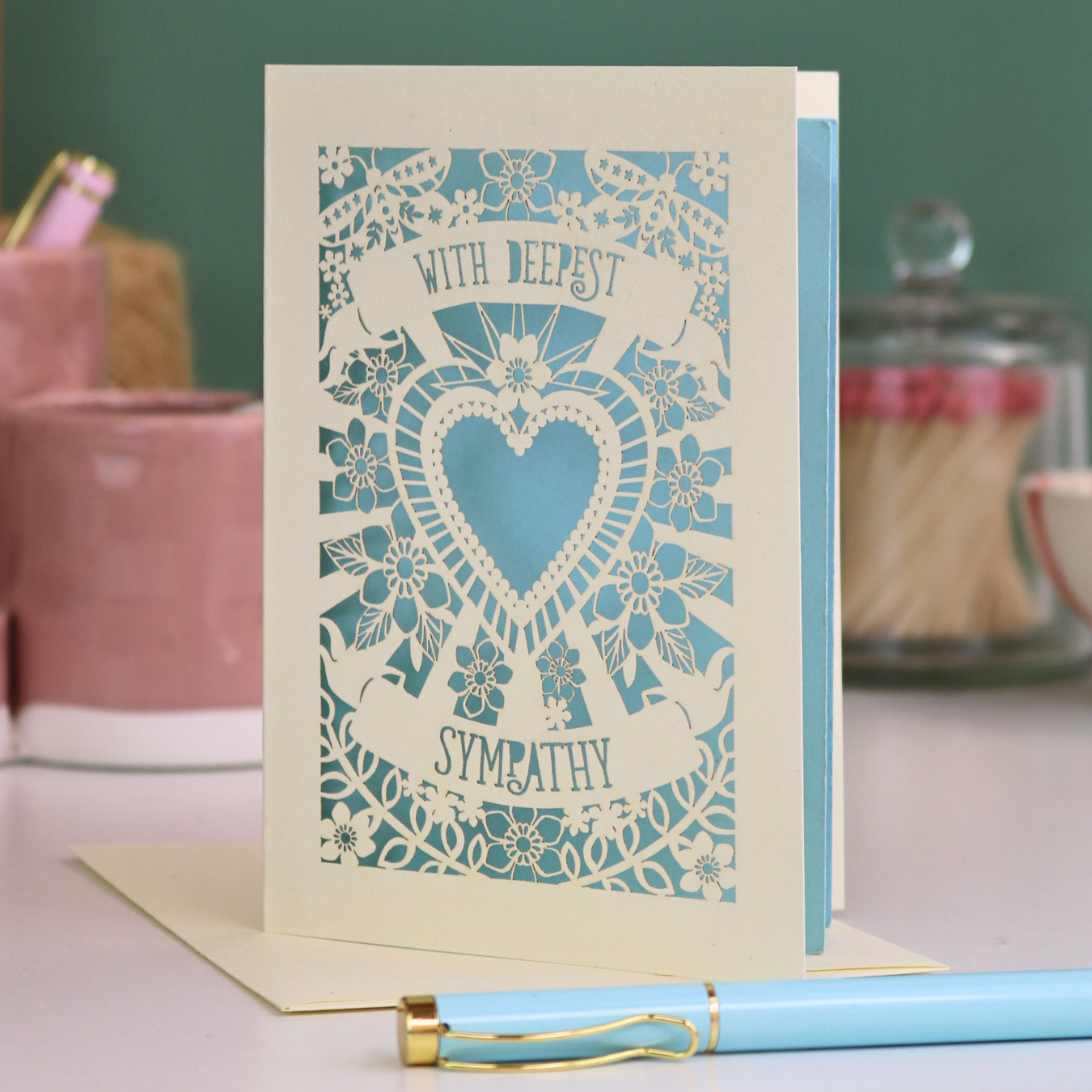 A cream laser cut sympathy card with cut out heart and flowers design and the text 'With Deepest Sympathy'