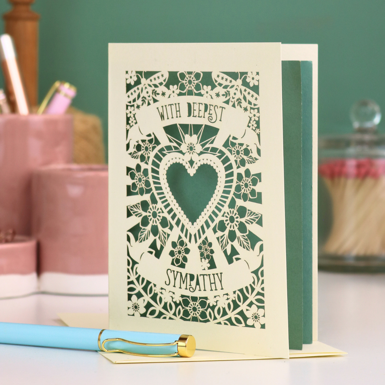 A cream laser cut bereavement card with cut out heart and flowers design and the text 'With Deepest Sympathy'