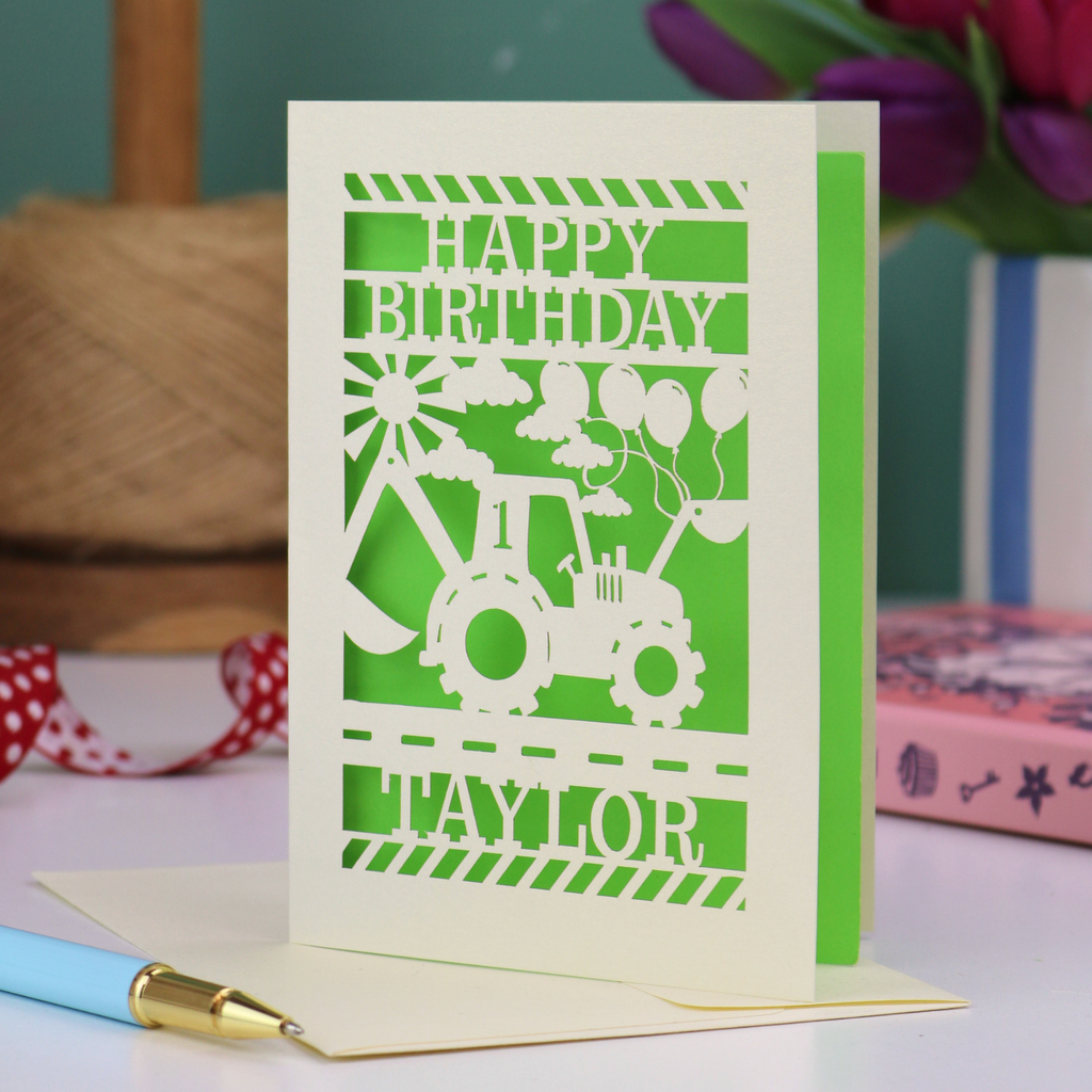A laser cut first birthday card with cut out digger and "HAPPY BIRTHDAY TAYLOR" personalised text. 