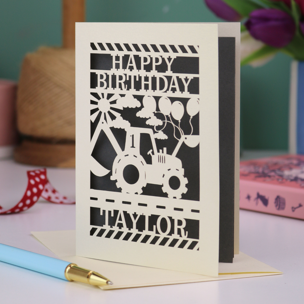 A laser cut first birthday card with cut out tractor and "HAPPY BIRTHDAY TAYLOR" personalised text. 
