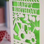 Close up photo of a laser cut birthday card with cut out tractor design