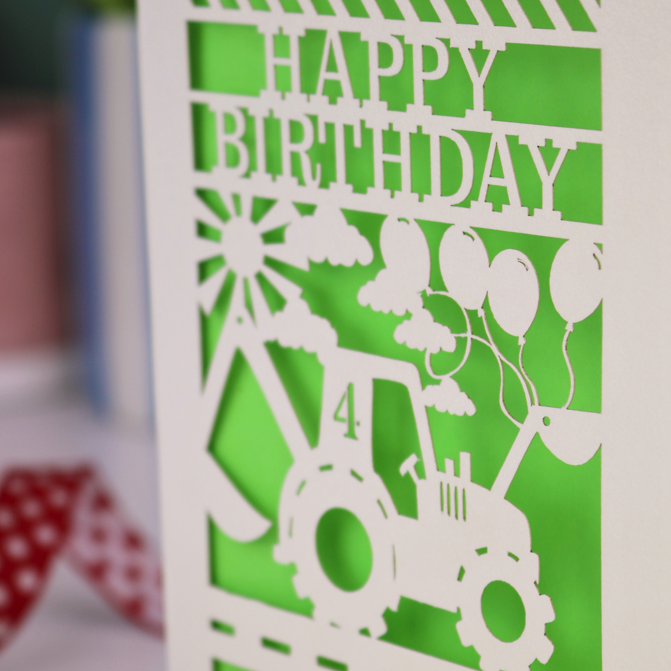 Close up photo of a laser cut birthday card with cut out tractor design