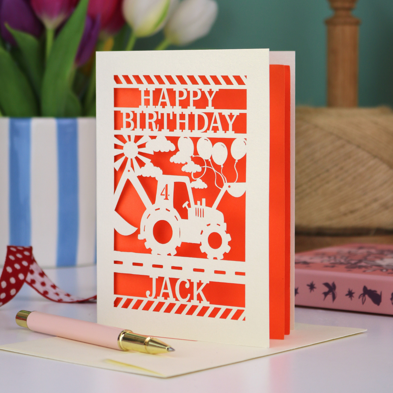 A birthday card for children, with laser cut digger design and "Happy Birthday" text, personalised with a name and age. 