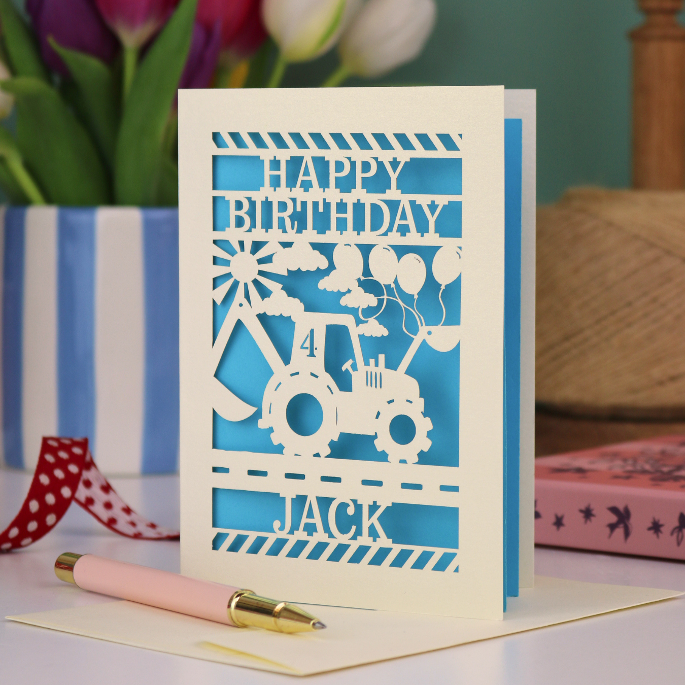 A birthday card for boys, with laser cut digger design and "Happy Birthday" text, personalised with a name and age. 