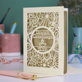 Cut out Diwali greeting card with intricate design and 'Diwali Greetings 2026' text on a desk.