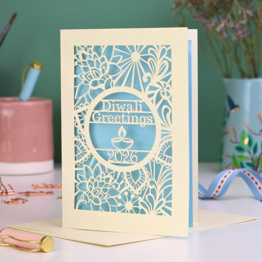 Laser Cut Diwali greetings card with intricate design and 'Diwali Greetings 2026' text on a desk.