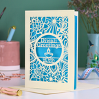 Laser Cut Diwali greetings card with intricate design and 'Diwali Greetings 2026' text on a desk.