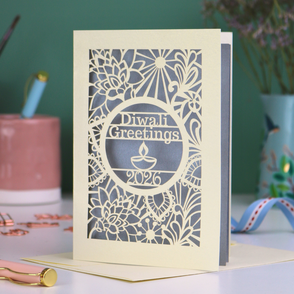 Laser Cut Diwali greetings card with intricate design and 'Diwali Greetings 2026' text on a desk.