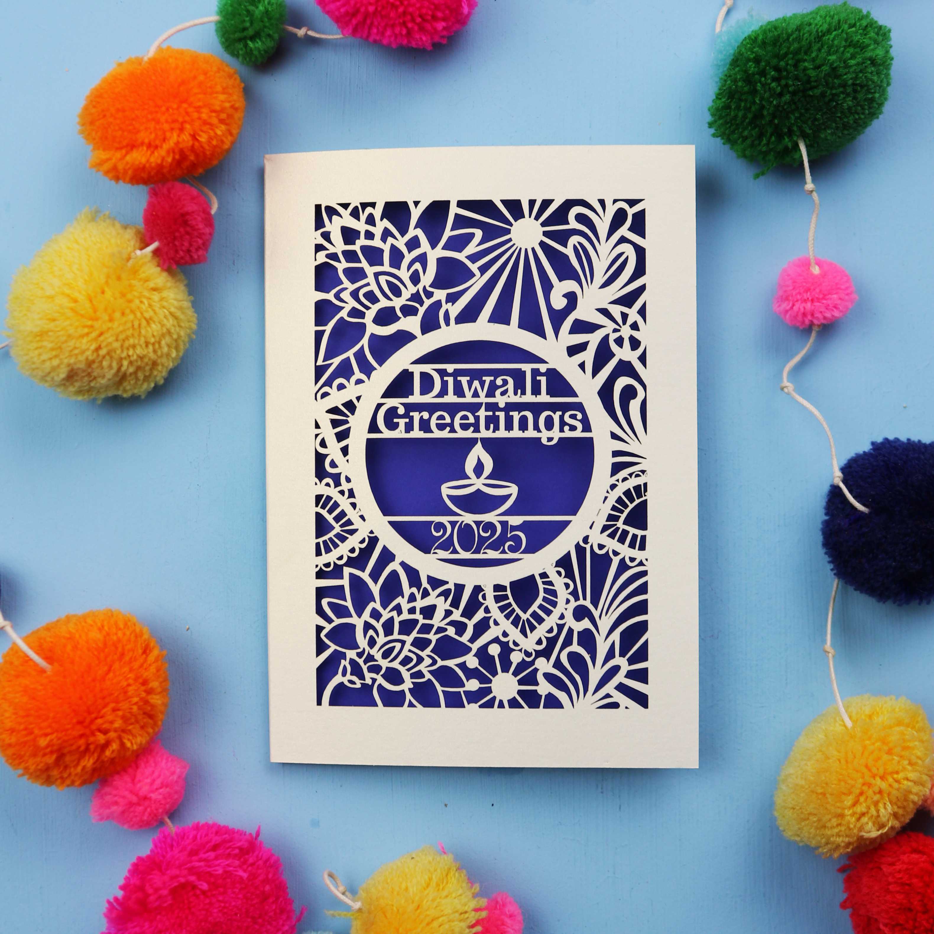 Laser Cut Diwali card with decorative elements on a blue background