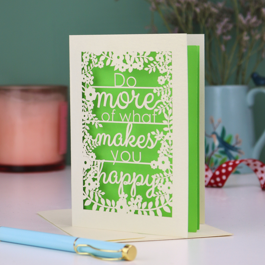 Laser cut out card for encouragement with motivational quote on a table with decorative items
