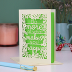 Laser cut out card for encouragement with motivational quote on a table with decorative items