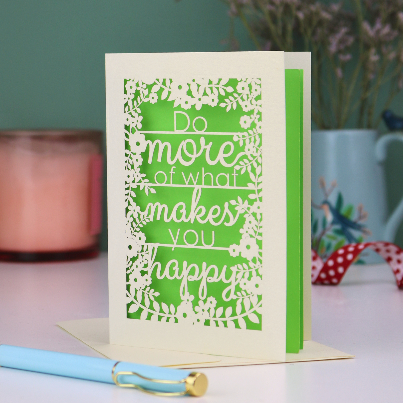 Laser cut out card for encouragement with motivational quote on a table with decorative items
