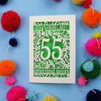 Emerald anniversary Card with '55 amazing years' design on a blue background with colourful pom-poms.