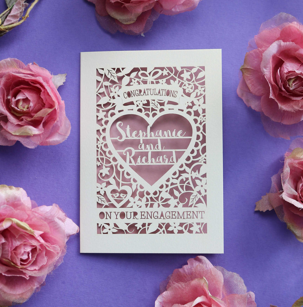 A cream and dusky pink engagement card personalised with names inside a heart