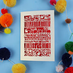 Luxury laser cut engagement Card with 'Congratulations on your engagement' text on a blue background with colourful pom-poms.