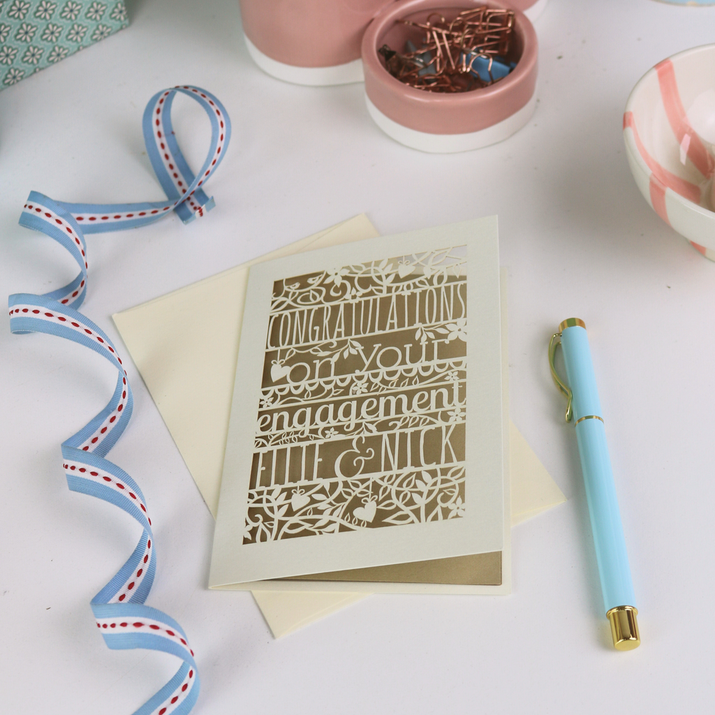 Personalized engagement card with decorative elements on a white surface