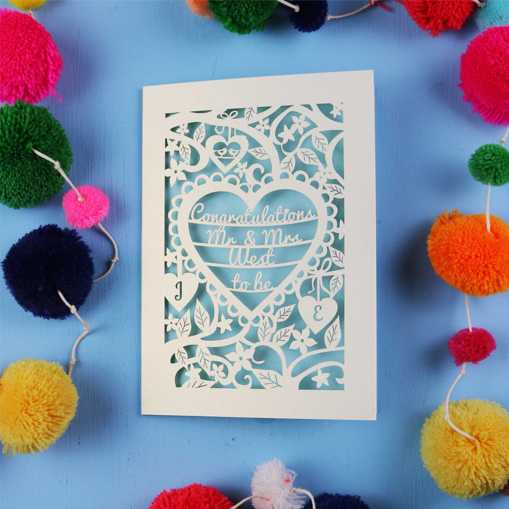 Decorative engagement card with 'Congratulations Mr & Mrs' text on a blue background with colourful pom-poms.