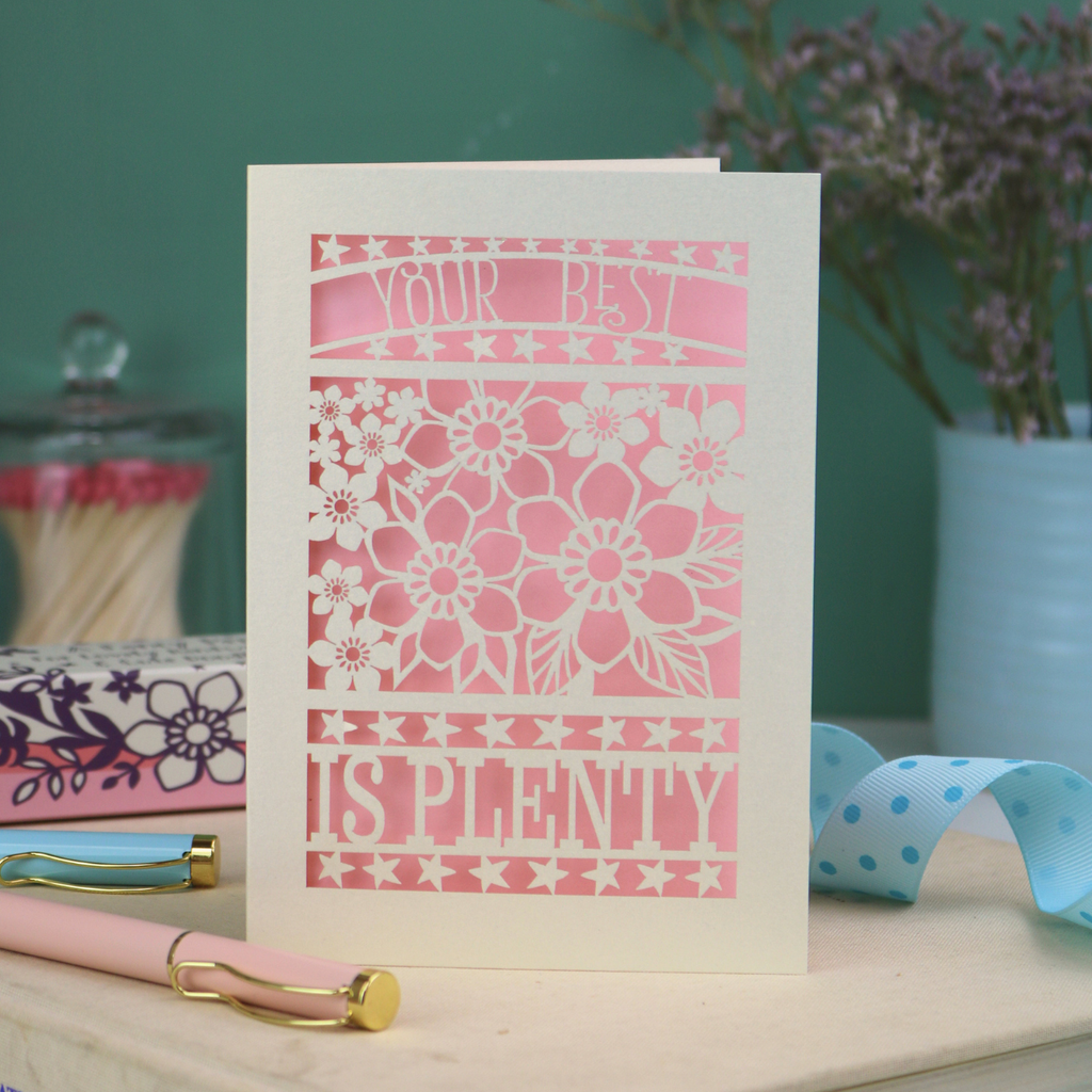 Decorative laser cut greetings card with floral design and text, 'Your best is plenty' on a table with stationery items.