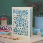 Decorative laser cut greetings card with floral design and text, 'Your best is plenty' on a table with stationery items.