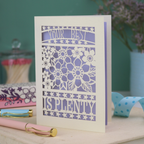 Decorative laser cut greetings card with floral design and text, 'Your best is plenty' on a table with stationery items.