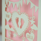 Decorative laser cut new baby greeting card with cut-out feet and heart design