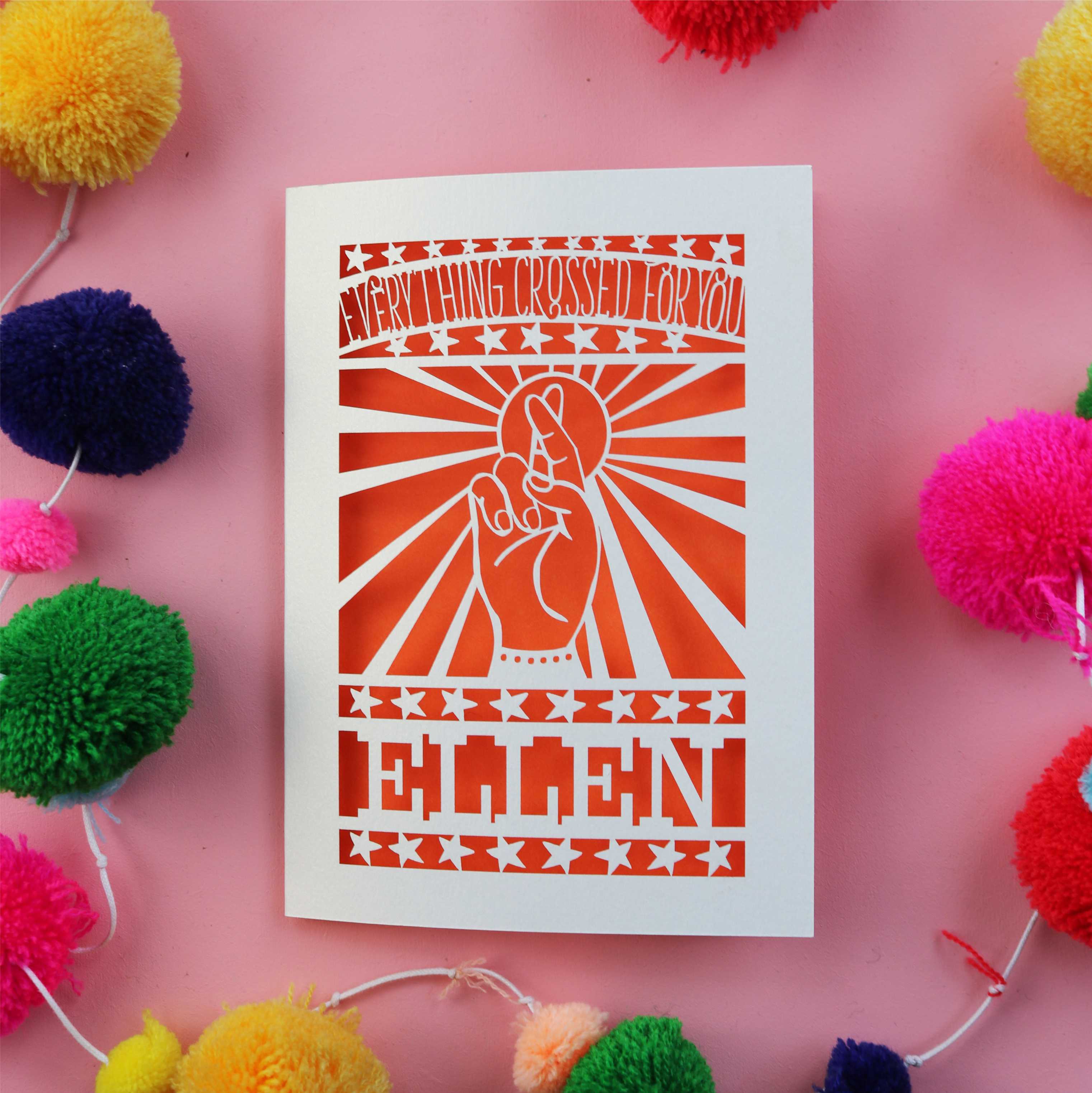 A papercut good luck card with crossed fingers and personalised with a name