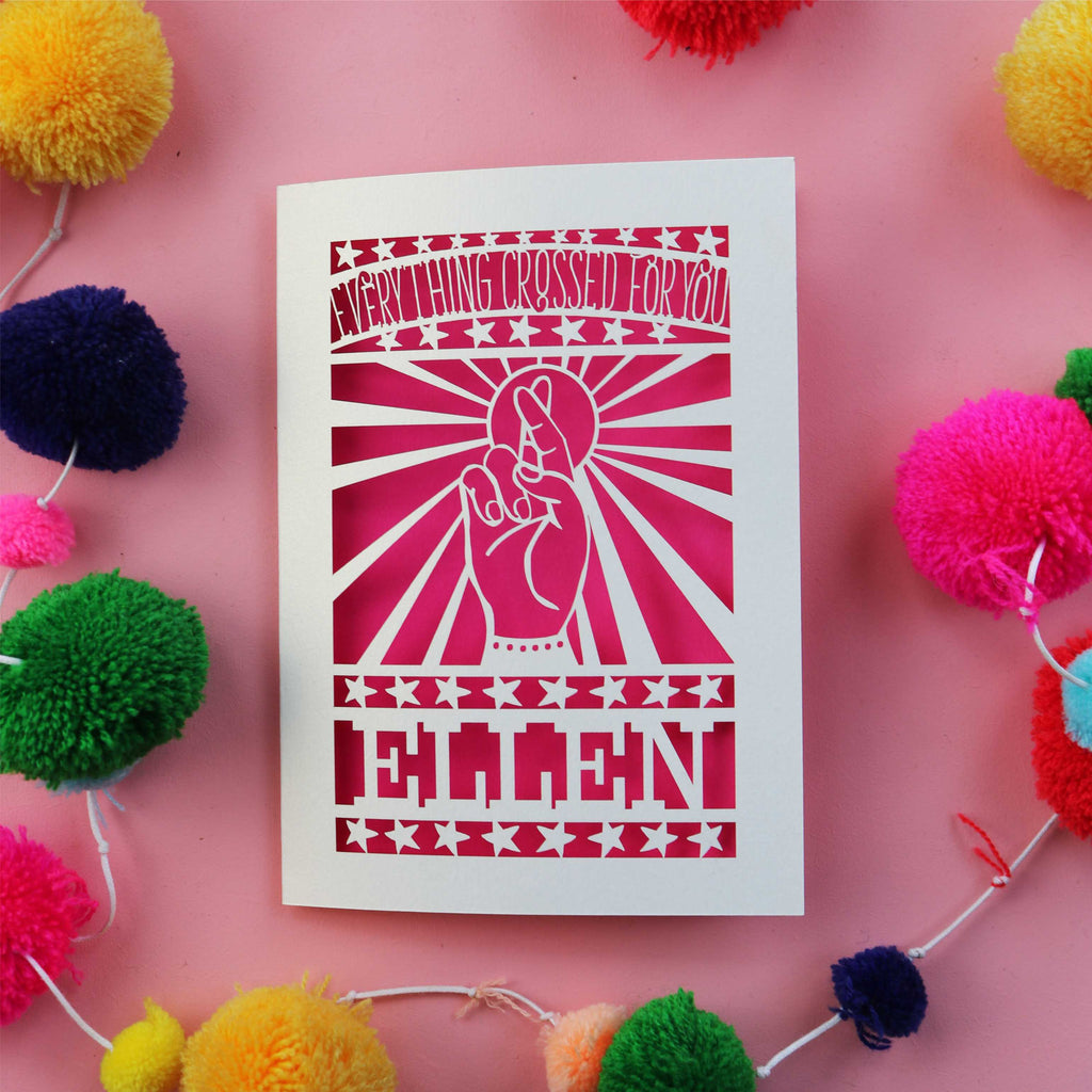 A cream and shocking pink laser cut card for good luck in exams. Card shows crossed fingers and the words "Everything crossed for you" with a name