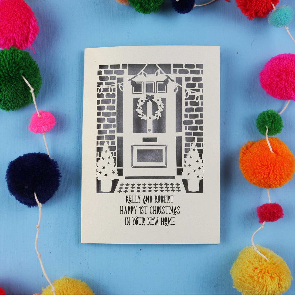 Christmas in your new home Card with festive design on a blue background with colourful pom-poms