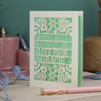 A floral laser cut 1st mother's day card with cut out text, "Happy First Mother's Day Love From" and is personalised with a name. 