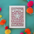 A laser cut first Christmas card personalised with a name and featuring a star surrounded by a floral border