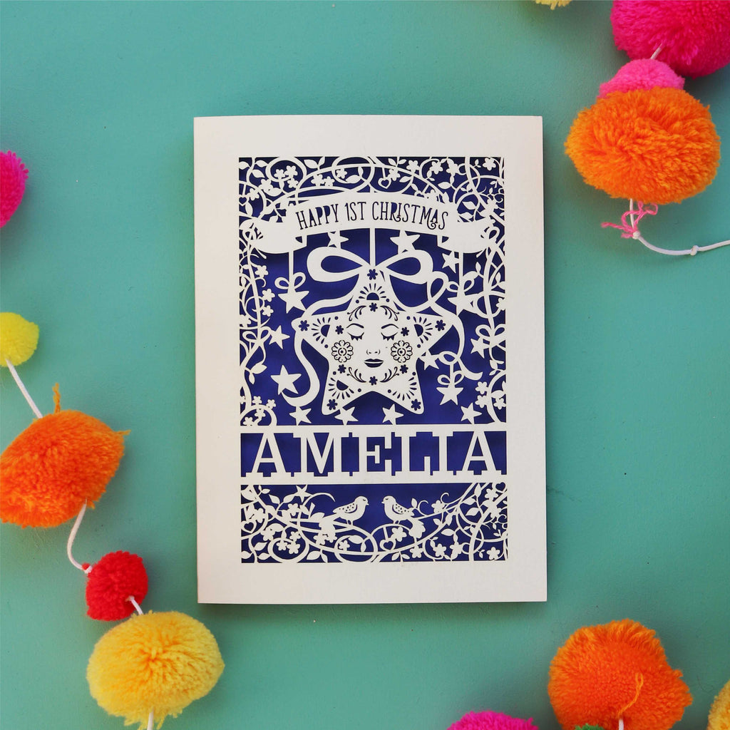 A Happy first Christmas laser cut card with a star and floral border. Card is personalised with baby's name