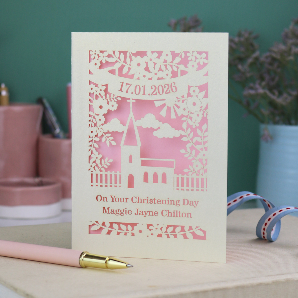 A laser cut floral Christening card with cut out church design and the date in a stencil font in a banner, with "On Your Christening Day" and the name "Maggie Jayne Chilton" underneath.