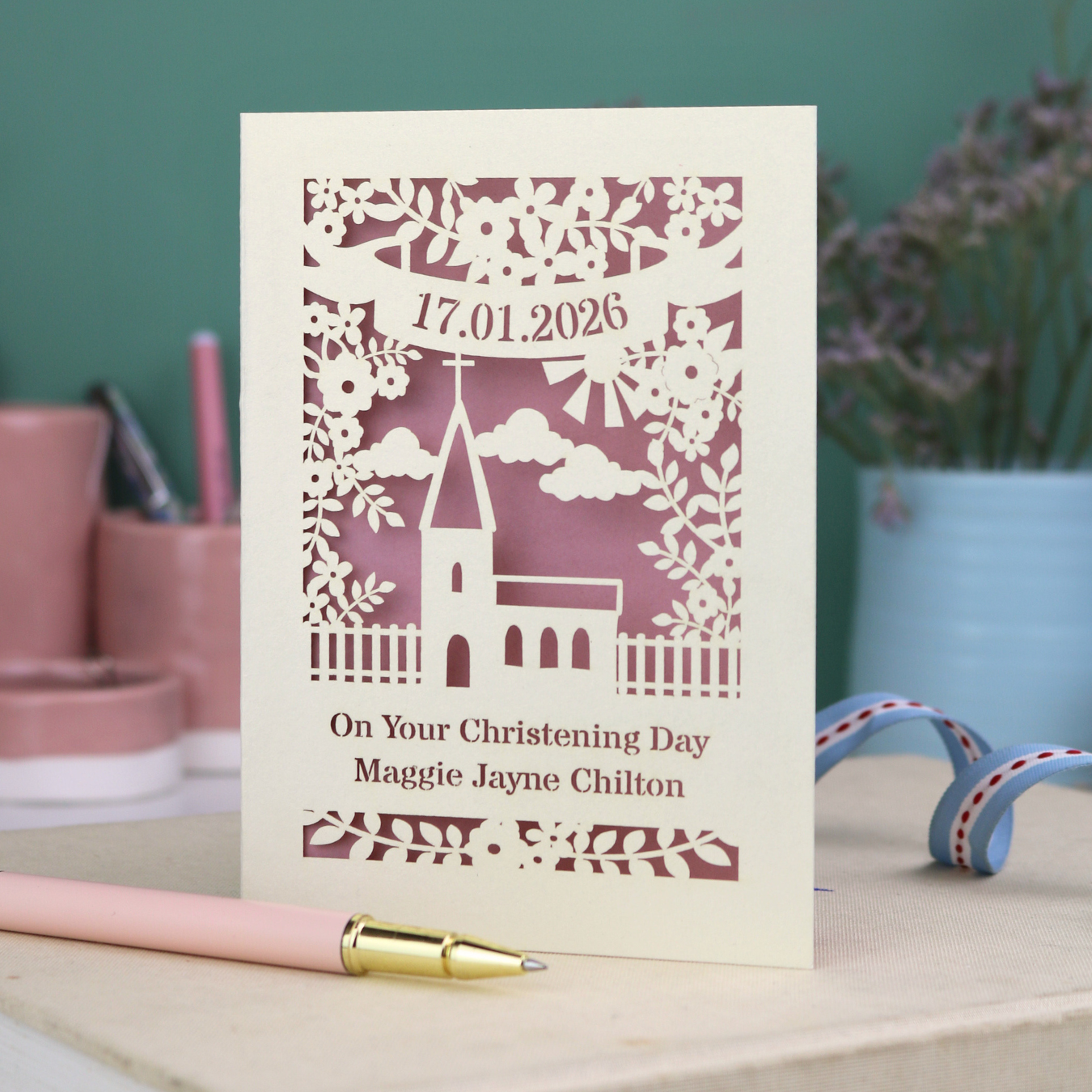 A laser cut floral Christening card with cut out church design and the date in a stencil font in a banner, with "On Your Christening Day" and the name "Maggie Jayne Chilton" underneath.