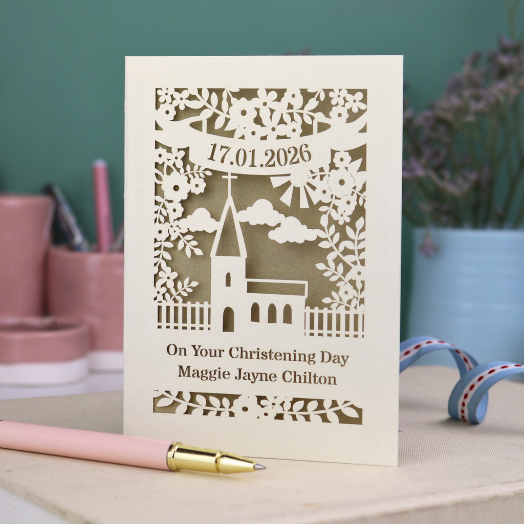 A laser cut floral Christening card with cut out church design and the date in a stencil font in a banner, with "On Your Christening Day" and the name "Maggie Jayne Chilton" underneath.