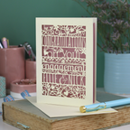 Engagement card with personalized text on a book with stationery items in the background