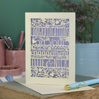Engagement card with personalized text on a book with stationery items in the background
