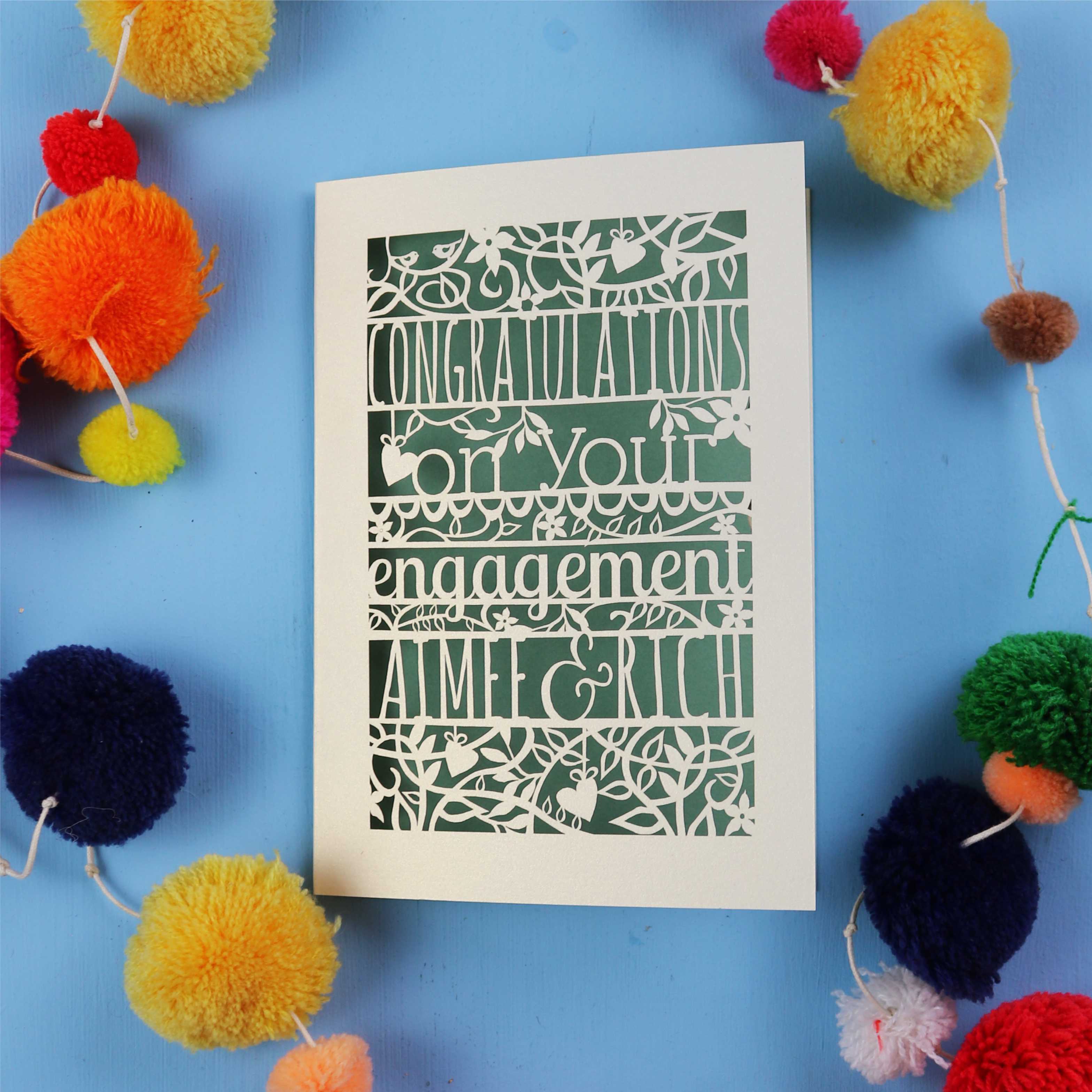 Luxury engagement Card with 'Congratulations on your engagement' text on a blue background with colourful pom-poms.