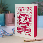 A personalised new baby card with laser cut floral stork design and "Welcome to the World" in cut out text in a banner, with the baby's date of birth and name
