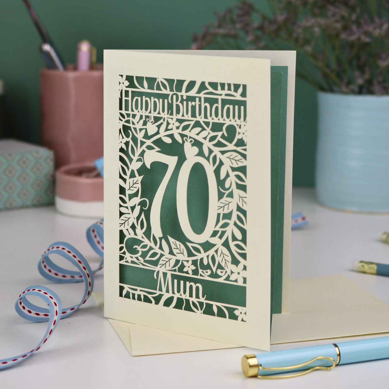 A personalised 70th birthday card, laser cut with floral design and 'Happy Birthday', with a name at the bottom and a big number 70 in the centre. 